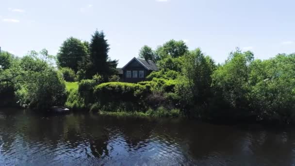 Beautiful view from river to shore with village house and boat in summer. Shot. Drone view of beautiful green beach with village fishermans house on sunny day — Stock Video