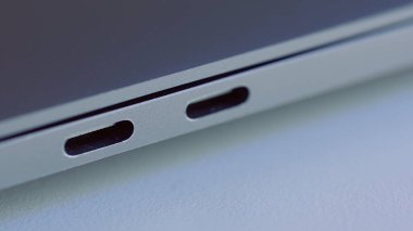 Zarif modern dizüstü bilgisayar detaylarını kapat. Başla. Modern teknolojiler kavramı, beyaz düz yüzey üzerinde yatan bir bilgisayarın USB portu.