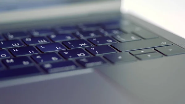 Close up of elegant modern laptop details. Action. Concept of modern technologies, Black keaboard and touch pad of a computer lying on white blurred background. — Stock Photo, Image