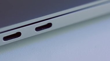 Zarif modern dizüstü bilgisayar detaylarını kapat. Başla. Modern teknolojiler kavramı, beyaz düz yüzey üzerinde yatan bir bilgisayarın USB portu.