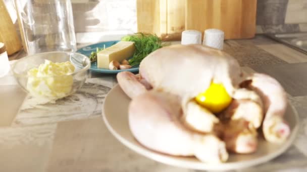 Sluiten van rauwe kip liggend op het bord op de keukentafel. Actie. Concept van gastronomie, vers kippenkarkas gevuld met citroen omgeven door andere ingrediënten om te koken. — Stockvideo