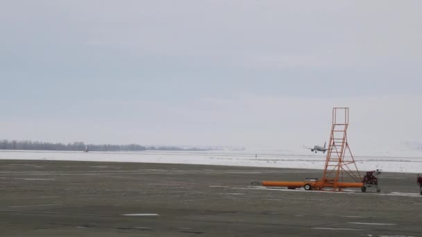 A gép a kifutópálya mentén készül leszállni télen. Készletfelvétel. Repülőgép a kifutópályán télen havas időjárás felhős háttér, koncepció a közlekedés. — Stock videók