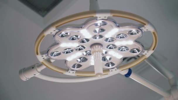 La lampada chirurgica o dentale a luce bianca in sala operatoria dell'ospedale. Azione. Vista in basso di una lampada professionale per illuminare una procedura chirurgica. — Video Stock