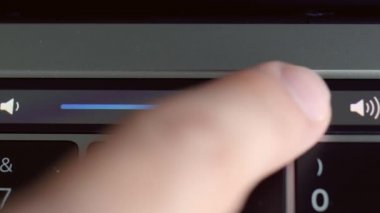 Laptop sensör panelinin detaylarını kapat. Başla. Modern bir bilgisayarın dokunmatik ses seviyesini ayarlayan erkek parmağı, teknoloji konsepti.