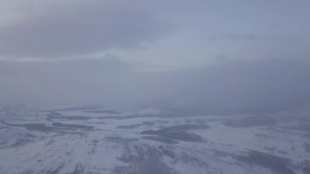 Flygfoto över den dimmiga morgonen i snöiga berg. Lagerbilder. Ändlösa snö öken och kullar på molnig himmel bakgrund, vinter naturlig bakgrund. — Stockvideo