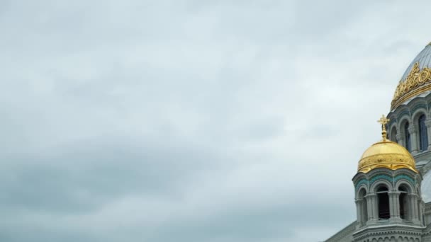 Белая православная церковь с большими золотыми куполами в облачный день. Концепция. Огромный соблазн против облачного неба, понятия религии и веры. — стоковое видео
