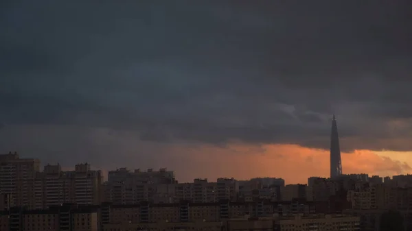 Centre Lakhta à Saint-Pétersbourg au coucher du soleil, Rusia. Concept. Immeuble de grande hauteur entouré de maisons résidentielles, centre d'affaires sur fond de grand coucher de soleil, effet time lapse. — Photo