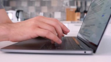 Laptop kullanan ve klavyede yazan bir adamın yan görüntüsü. Başla. Evde bilgisayarında çalışırken erkek ellerinin mektup yazmasını kapat, serbest çalışma kavramı..
