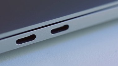 Zarif modern dizüstü bilgisayar detaylarını kapat. Başla. Modern teknolojiler kavramı, beyaz düz yüzey üzerinde yatan bir bilgisayarın USB portu.