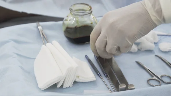 Steril sebészeti eszközök közelsége a műtéthez. Felvétel. Kezét egy orvos védő tiszta kesztyű vesz egy speciális eszköz sthe művelet. — Stock Fotó