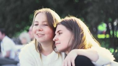 Lezbiyen çift güneşli bir günde parkta dinleniyor. Medya. Bir çift güzel lezbiyen yeşil parkta güneşli bir günün tadını çıkarıyor. Homoseksüellik ve lezbiyen ilişkilerin teması. LGBT kavramı