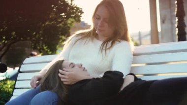 Lezbiyen çift güneşli bir günde parkta dinleniyor. Medya. Bir çift güzel lezbiyen yeşil parkta güneşli bir günün tadını çıkarıyor. Homoseksüellik ve lezbiyen ilişkilerin teması. LGBT kavramı