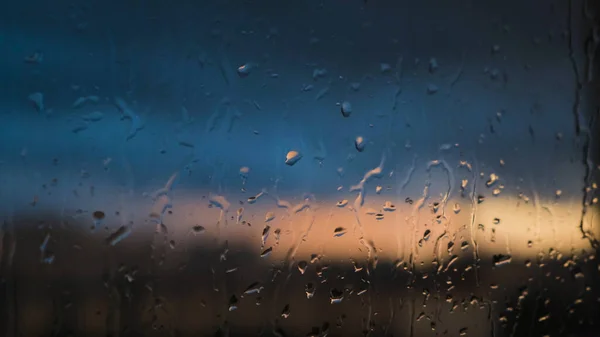 Detailní záběr okna s kapkami deště na pozadí zataženou oblohou. Koncept. Krásné dešťové pozadí s kapkami deště na sklo. Dešťové kapky při spuštění okna — Stock fotografie