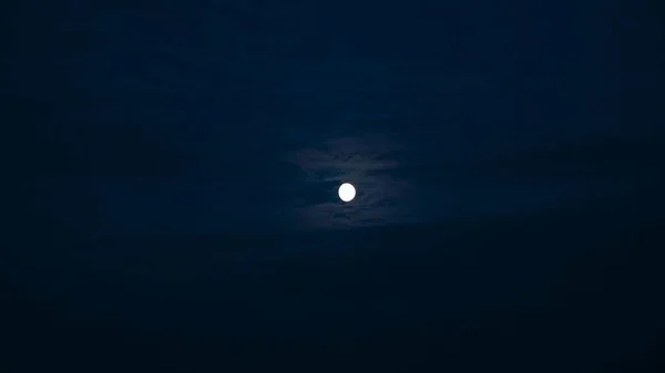 満月と雲を渡すと夜空のビュー。コンセプト。月に照らされた美しい暗い空を持つ野生の自然。満月と曇りの夜の空 — ストック写真