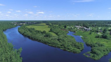 Nehirleri ve arka planda mavi gökyüzü olan köyü olan yeşil ormanın en üst görüntüsü. Vuruldu. Yeşil orman ve mavi nehirlerle güzel bir yaz manzarası