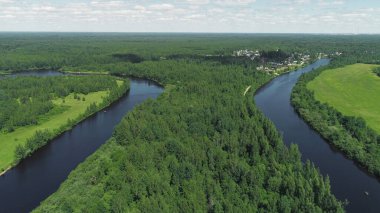 Nehirleri ve arka planda mavi gökyüzü olan köyü olan yeşil ormanın en üst görüntüsü. Vuruldu. Yeşil orman ve mavi nehirlerle güzel bir yaz manzarası