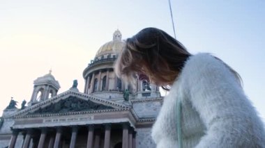 Güzel genç bir kadın telefonda Katedral 'in fotoğraflarını çekiyor. Kavram. Çekici kadın, eski şehirde popüler olan Kubbeli Katedral 'in fotoğraflarını çekiyor.