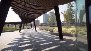 Güneşli bir günde modern pergolas parkta. Başla. Modern şehir parkındaki uzun pavyonlar veya pergolalar. Parktaki dinlenme alanları için güzel mimari çözümler