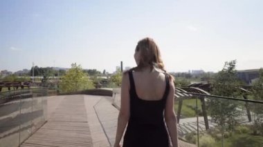 Parkta kamera izleme platformu olan güzel bir kadın. Başla. Kadın, şehir parkındaki modern gözlem güvertesinden kamera ile fotoğraf çekiyor.