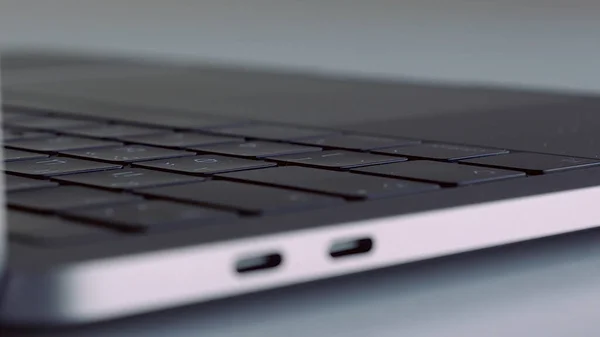 Zamknij widok z boku nowego laptopa z czarną klawiaturą na białym tle. Akcja. Prezentacja nowego nowoczesnego urządzenia technologicznego. — Zdjęcie stockowe