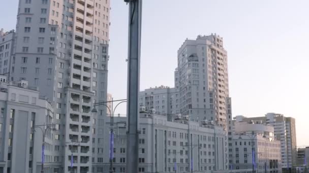 Luxurious new apartament house with a white facade. Stock footage. Summer city street and the complex of buildings, modern district of a big city on blue sky background. — Stock Video