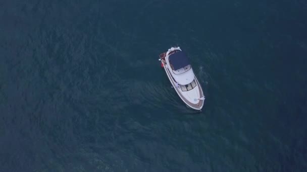 Aerial top view of a luxury white yacht and relaxing people. Clip. Concept of summer vacation, beautiful sail boat cruising in deep blue Aegean sea. — Stock Video