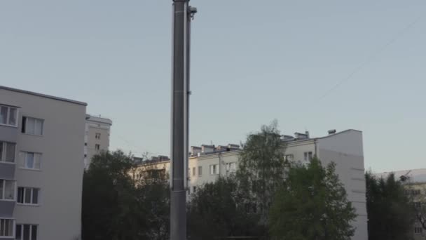 Macchina fotografica che si muove intorno alla lanterna nella strada di una città moderna. Filmati delle scorte. Città e case residenziali, condominio non costruito e cielo blu. — Video Stock