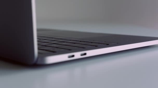 Vista lateral cercana de un nuevo portátil con teclado negro sobre fondo blanco. Acción. Presentación de nuevo dispositivo tecnológico moderno. — Vídeo de stock
