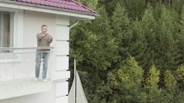 L'uomo tiene una farfalla sulla mano e la esamina e ammira la bellezza dell'insetto. Un video. L'uomo sta cercando di far volare via gli insetti sullo sfondo verde della foresta. — Video Stock