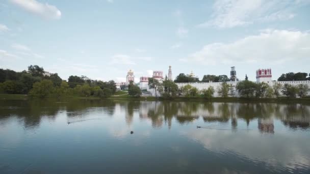 Monastery ensemble with pond. Action. Beautiful landscape with monastery surrounded by white wall by pond. Russian landscapes of monasteries — Stock Video