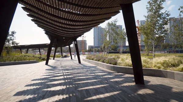 Güneşli bir günde modern pergolas parkta. Başla. Modern şehir parkındaki uzun pavyonlar veya pergolalar. Parktaki dinlenme alanları için güzel mimari çözümler