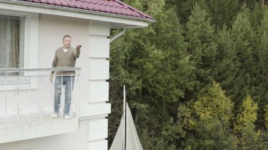 İnsan elinde bir kelebek tutar ve onu inceler ve böceğin güzelliğine hayran kalır. Video kaydı. İnsanoğlu yeşil orman arka planında böcekleri kaçırmaya çalışıyor..