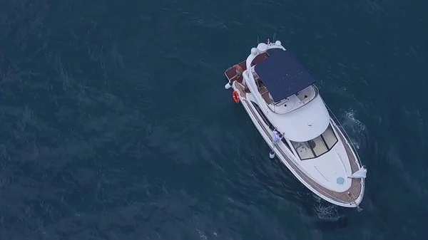 Luftaufnahme einer weißen Luxusjacht und entspannter Menschen. Clip. Konzept des Sommerurlaubs, schöne Segelbootfahrt in der tiefblauen Ägäis. — Stockfoto