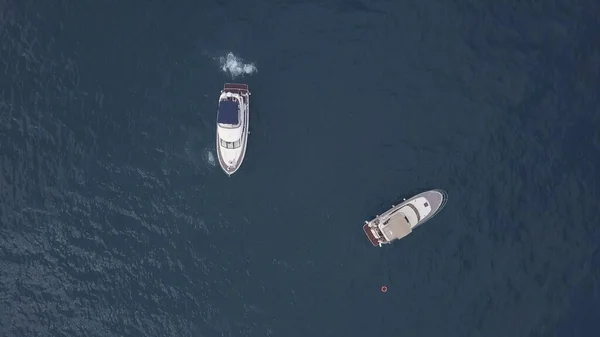 Incrível vista aérea superior de dois iates e amigos nadadores em água azul escura. Clipe. Pessoas se divertindo no mar paraíso caribenho perto de novos barcos à vela. — Fotografia de Stock