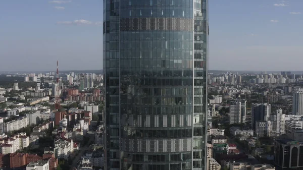 Vista aérea del rascacielos Vysotsky en la ciudad de Ekaterinburg en Rusia. Imágenes de archivo. Volando hacia la fachada de vidrio edificio alto en el fondo del paisaje urbano moderno, concepto de arquitectura. — Foto de Stock