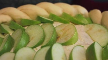 Evde Charlotte elmasının hazırlanması, manzarayı kapat. Stok görüntüleri. Taze kesilmiş yeşil elma parçacıkları çiğ hamur tarafından, at kuyruğu şeklinde, pişirme kavramı..