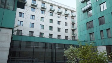 Modern tasarım ve yeşil renkli çok katlı bir bina. Başla. Sessiz avlusu olan modern apartman cephesi