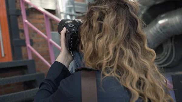 फोटो शूट के दौरान महिला फोटोग्राफर का बैक व्यू। कार्रवाई प्रोफेशनल महिला फोटोग्राफर फोटो शूट पर कमांड और सुधार मॉडल देता है। फोटोग्राफर का पेशा — स्टॉक फ़ोटो, इमेज