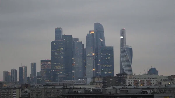 Belos arranha-céus de vidro no fundo céu nublado à noite. Acção. Paisagem urbana com negócios brilhantes arranha-céus em tempo nublado. Vista do centro de negócios da cidade de Moscou na noite nublada — Fotografia de Stock