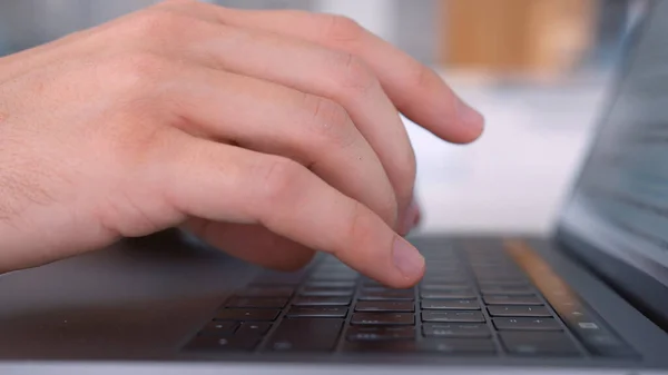 Sidovy av en man som använder bärbar dator och skriver på tangentbordet. Börja. Närbild av manliga händer skriva ett brev när du arbetar hemma på sin dator, begreppet frilans. — Stockfoto