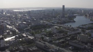 Rusya 'nın Ekaterinburg şehrinin merkezinin havadan görüntüsü. Stok görüntüleri. Bulutlu arka planda bulvarlar, evler ve akan nehirlerle dolu yaz şehri..