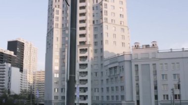 Beyaz yüzlü lüks bir apartman dairesi. Stok görüntüleri. Summer City sokağı ve binalar kompleksi, mavi gökyüzü arka planında büyük bir şehrin modern bölgesi..