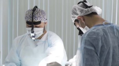 Hastanedeki tıp cerrahları cerrahi operasyon yapıyor. Başla. Acil Servis 'te temiz üniformalı adamlar prosedürü uyguluyor..