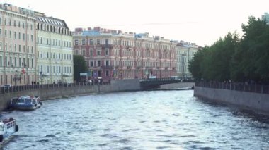 Rusya, Saint Petersburg 'daki Moyka Nehri' nin seti. Medya. Yaz günü ve dalgalı nehir boyunca büyüyen eski evler ve yeşil ağaçlarla dolu şehir manzarası..