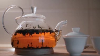 Cam çaydanlıkta çay demliyorum. Kavram. Beyaz fincanlarla şeffaf çaydanlıkta demlenen güzel çay. Çin çayı demleme sanatı. Çay töreni.