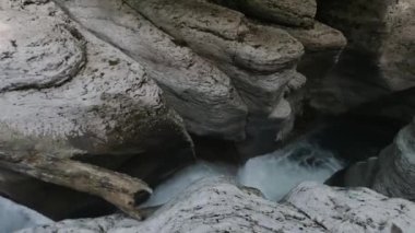 Dar geçitteki kayaların arasından akan dağlık nehir akıntısı. Şarjör. Soğuk tatlı su ile su akıntısı ve bir sürü beyaz kaya..