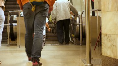 Metro istasyonu ve yürüyen merdiven inip çıkıyor. Medya. İnsanlar metro istasyonunun mekanik merdivenlerine doğru yürüyorlar, toplu taşıma kavramı.