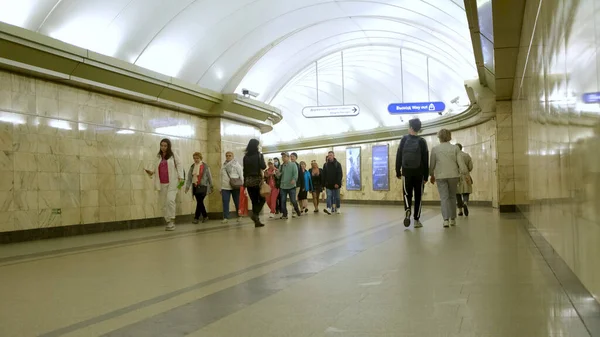 Menschen, die in der U-Bahn-Station gehen, Konzept des öffentlichen Nahverkehrs. Medien. Menschenmenge läuft durch den langen Gang in U-Bahn-Station. — Stockfoto