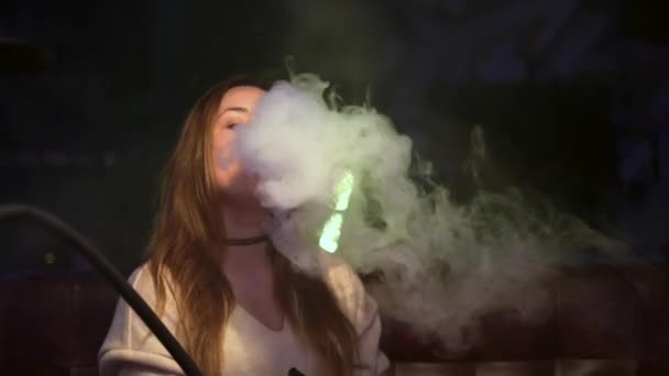 Bekar kadın güzel nargile içiyor. Medya. Genç kadın nargile yakarken duman bulutları salıyor. Nargile içme sanatı — Stok video