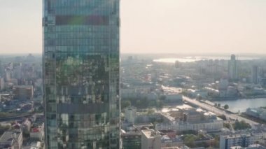 Şehrin üst manzarası cam iş gökdeleninin camlarına yansıyor. Stok görüntüleri. Güneşli bir günde şehrin arka plandaki cam gökdelendeki güzel yansıması.